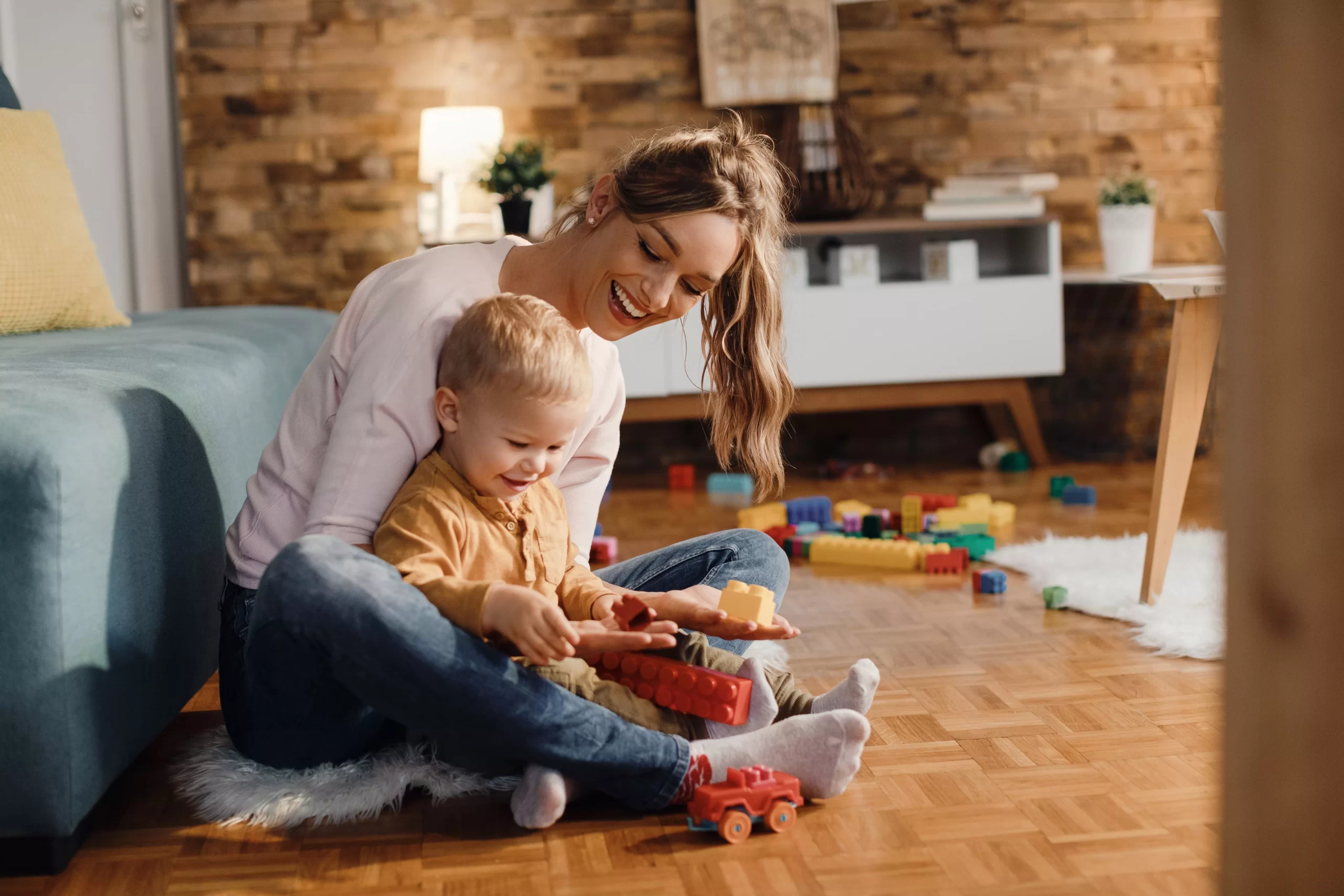 happy-mother-son-playing-with-toy-blocks-living-room